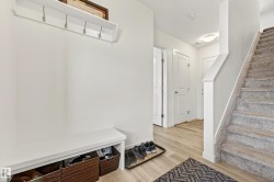 Entryway featuring wood-finish flooring and a carpeted staircase - 