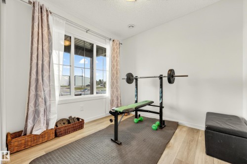 Naturally lit room featuring light wood-finish flooring, white walls, and a large window with white trim - 38 Jensen Gate, St. Albert, AB - Indoor Photo Showing Gym Room