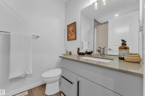 Bathroom featuring a vanity with a light-toned countertop, undermount sink, and contemporary faucet - 17319 2 St Nw, Edmonton, AB - Indoor Photo Showing Bathroom