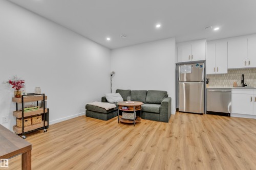 Open-concept living space featuring wood-finish flooring, recessed lighting, and white walls - 17319 2 St Nw, Edmonton, AB - Indoor Photo Showing Kitchen
