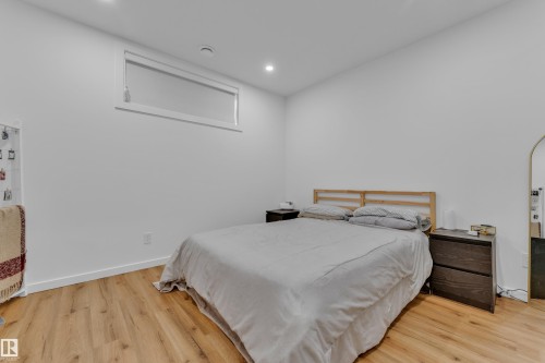 Bedroom featuring wood-finish flooring, a contemporary window, recessed lighting, and crisp white walls - 17319 2 St Nw, Edmonton, AB - Indoor Photo Showing Bedroom