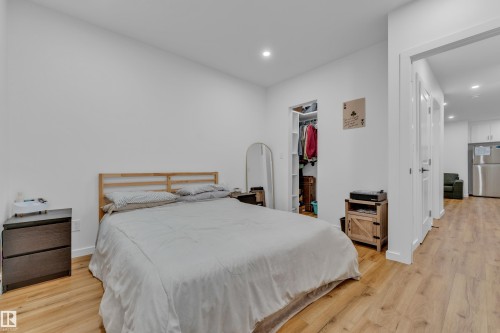 Bedroom featuring wood-finish flooring, recessed lighting, and a closet with built-in shelving - 17319 2 St Nw, Edmonton, AB - Indoor Photo Showing Bedroom