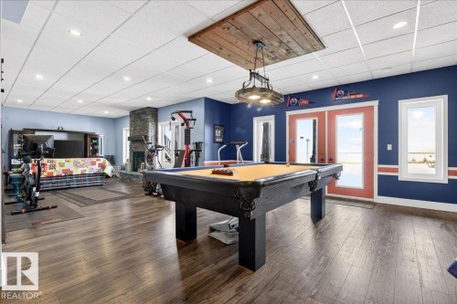 Living area featuring a stone fireplace with a wood mantle, recessed lighting, and light blue walls - 531064 Range Road 174, Rural Lamont County, AB - Indoor Photo Showing Other Room With Fireplace