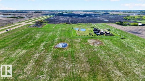 This property features a substantial main residence with a prominent dark-colored roof, surrounded by expansive snow-covered grounds - 531064 Range Road 174, Rural Lamont County, AB - Outdoor With Body Of Water With View
