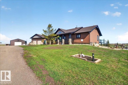 The property features an extensive yard with a putting green, a pond, and a gravel perimeter - 531064 Range Road 174, Rural Lamont County, AB - Outdoor With View