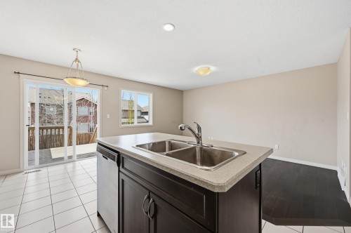 Kitchen island featuring a dual stainless steel sink and integrated dishwasher - 2170 52A Street Sw, Edmonton, AB - Indoor Photo Showing Kitchen With Double Sink