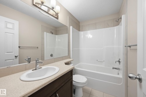 Bathroom featuring a spacious vanity with an integrated sink, polished chrome faucet, and a large mirror - 2170 52A Street Sw, Edmonton, AB - Indoor Photo Showing Bathroom