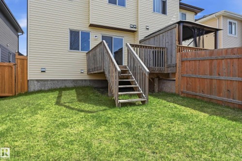 Expansive green lawn with a wooden deck featuring stairs, a privacy wall, and a covered pergola structure - 2170 52A Street Sw, Edmonton, AB - Outdoor With Exterior