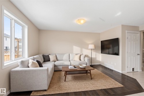 Living area featuring dark wood-finish flooring with a contrasting area rug - 2170 52A Street Sw, Edmonton, AB - Indoor Photo Showing Living Room