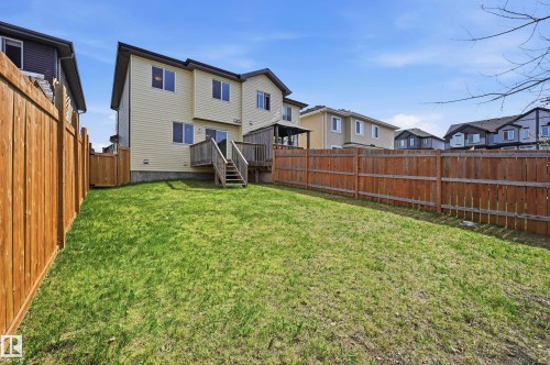 Expansive backyard featuring a manicured lawn, full privacy fencing, and a multi-level wood deck with a pergola - 2170 52A Street Sw, Edmonton, AB - Outdoor
