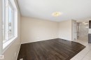 Spacious living area featuring dark wood-finish flooring, neutral wall tones, and white trim - 2170 52A Street Sw, Edmonton, AB  - Indoor Photo Showing Other Room 