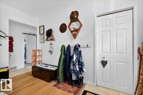 Entryway featuring wood-finish flooring, white paneled bifold closet doors, and recessed lighting - 4212 105 Avenue, Edmonton, AB - Indoor Photo Showing Other Room