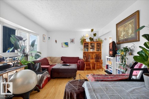 Light wood-finish flooring complements the white walls and ceiling - 4212 105 Avenue, Edmonton, AB - Indoor Photo Showing Living Room