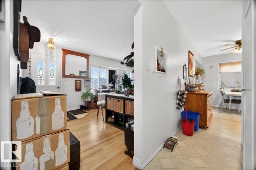 Entryway featuring hardwood flooring, a decorative front door with stained glass accents, and a ceiling-mounted light fixture - 4212 105 Avenue, Edmonton, AB - Indoor Photo Showing Other Room