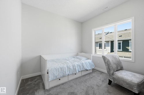 Carpeted room featuring a large multi-pane window, white trim, and a high ceiling - 34 2905 141 Street, Edmonton, AB - Indoor Photo Showing Bedroom