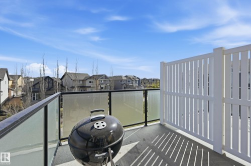 Balcony featuring a concrete surface, glass and metal railings, and a white privacy screen - 34 2905 141 Street, Edmonton, AB - Outdoor