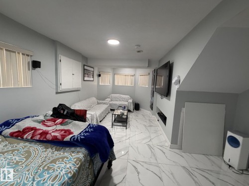 Spacious room featuring white marble-look tile flooring and light gray walls - 3139 34B Avenue, Edmonton, AB - Indoor Photo Showing Bedroom
