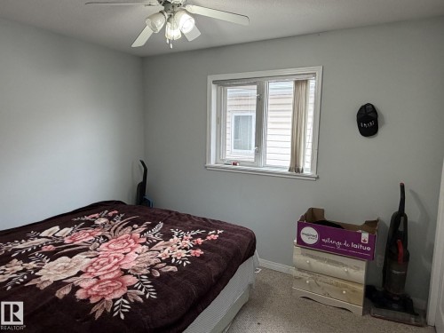 Bedroom featuring light gray walls, a ceiling fan with integrated lighting, and a white-framed window - 3139 34B Avenue, Edmonton, AB - Indoor Photo Showing Bedroom