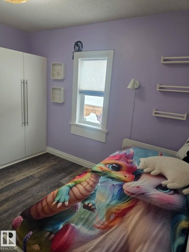 Room featuring wood-finish flooring and a window. - 4825 52 Street, Elk Point, AB - Indoor Photo Showing Bedroom