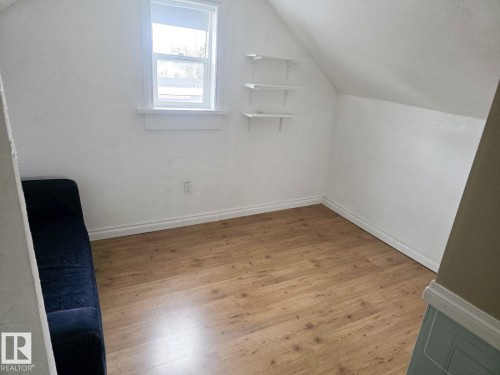 Room featuring wood-finish flooring, white baseboards, and a window with white trim - 4825 52 Street, Elk Point, AB - Indoor Photo Showing Other Room