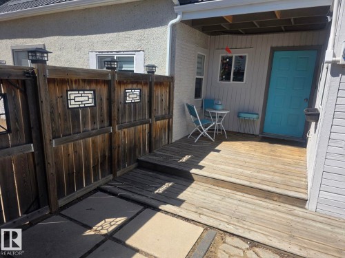 Wood-finish deck with a turquoise entry door. - 4825 52 Street, Elk Point, AB - Outdoor With Deck Patio Veranda With Exterior