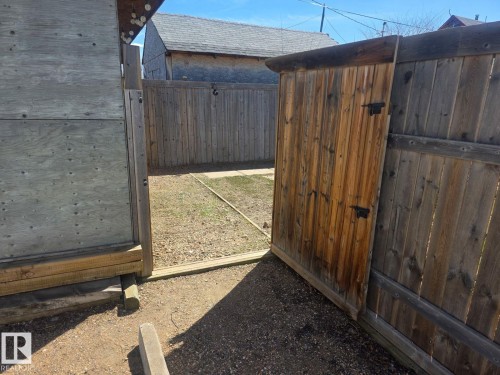 Wood privacy fence with an integrated wooden gate featuring black hardware. - 4825 52 Street, Elk Point, AB - Outdoor