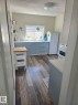Kitchen featuring light blue lower cabinetry with silver hardware, white countertops, and wood-finish flooring. - 4825 52 Street, Elk Point, AB  - Indoor Photo Showing Laundry Room 