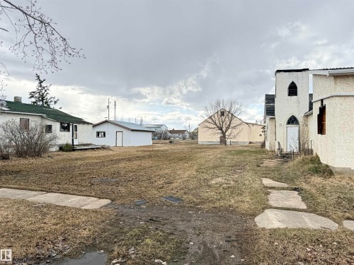 Expansive lot featuring a concrete sidewalk and flagstone pathway - 5036 49 Street, Clyde, AB - Outdoor