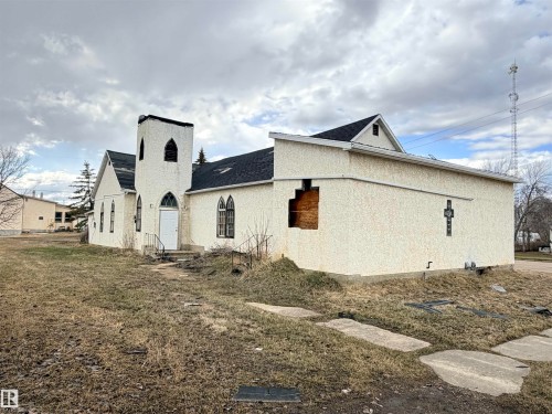 Stucco exterior building featuring a prominent front steeple and a gabled roofline - 5036 49 Street, Clyde, AB - Outdoor