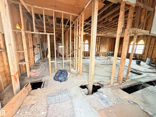 Framed interior structure with visible joists and framing, arched windows, and exposed subflooring - 5036 49 Street, Clyde, AB - Indoor