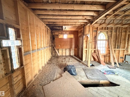 Exposed wood framing and open ceiling joists define this interior space - 5036 49 Street, Clyde, AB - Indoor