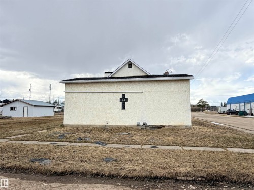 Stucco exterior featuring an ornamental cross detail - 5036 49 Street, Clyde, AB - Outdoor