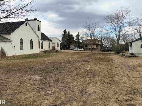 Building with white stucco exterior and black-trimmed arched windows - 5036 49 Street, Clyde, AB - Outdoor