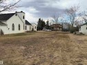 Building with white stucco exterior and black-trimmed arched windows - 5036 49 Street, Clyde, AB  - Outdoor 