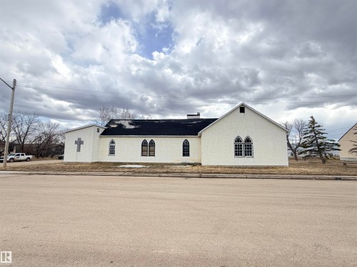White stucco exterior with a black asphalt shingle roof - 5036 49 Street, Clyde, AB - Outdoor