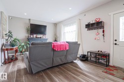 Living area with wood-finish flooring and recessed lighting - 