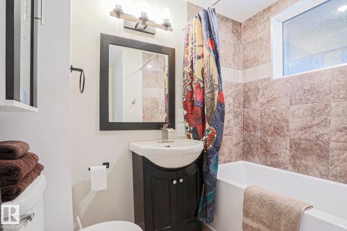Bathroom with a white soaking tub and brown tiled surround - 5113 53 Avenue, Stony Plain, AB - Indoor Photo Showing Bathroom