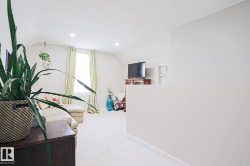 Carpeted upper-level space featuring recessed lighting, an accent window with light-colored drapes, and a partial wall element - 5113 53 Avenue, Stony Plain, AB - Indoor Photo Showing Other Room