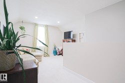 Carpeted upper-level space featuring recessed lighting, an accent window with light-colored drapes, and a partial wall element - 