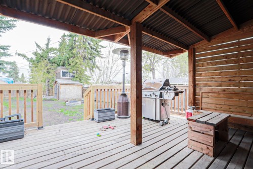 Expansive wooden deck featuring a corrugated metal roof, slatted wood privacy wall, and wooden railings - 5113 53 Avenue, Stony Plain, AB - Outdoor With Deck Patio Veranda With Exterior