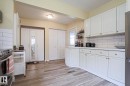 Contemporary kitchen featuring white cabinetry, subway tile backsplash, wood-finish flooring, white countertops, and stainless steel appliances - 5113 53 Avenue, Stony Plain, AB  - Indoor Photo Showing Kitchen 