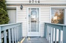 Front entry featuring a storm door, an exterior wall light fixture, and horizontal siding - 9716 162 Street, Edmonton, AB  - Outdoor With Exterior 