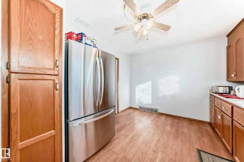 Kitchen area featuring wood-finish flooring, white walls, and a ceiling fan with light kit - 9716 162 Street, Edmonton, AB - Indoor Photo Showing Kitchen