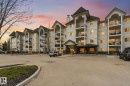 Multi-story residential building featuring a light-colored stucco exterior with dark-pitched roofs - 407 13635 34 Street Nw, Edmonton, AB  - Outdoor With Balcony With Facade 