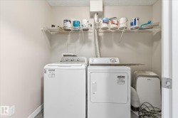 Dedicated laundry area featuring a wire rack shelf for storage, neutral wall paint, and wood-finish flooring - 