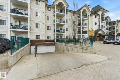 Multi-story residential building featuring light-toned siding and multiple balconies with dark railings - 407 13635 34 Street Nw, Edmonton, AB - Outdoor With Balcony With Facade