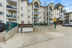 Multi-story residential building featuring light-toned siding and multiple balconies with dark railings - 