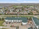 Multi-story residential building featuring a green pitched roof and light-colored siding - 407 13635 34 Street Nw, Edmonton, AB  - Outdoor With View 