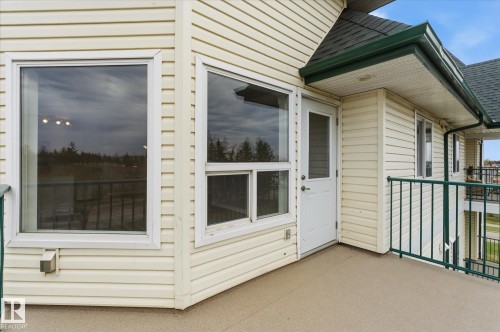 Exterior balcony featuring an entry door and multiple windows - 407 13635 34 Street Nw, Edmonton, AB - Outdoor With Exterior