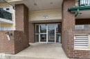 Building entrance featuring a glass double door, brick columns, and a covered entryway with horizontal siding - 407 13635 34 Street Nw, Edmonton, AB  - Outdoor With Exterior 